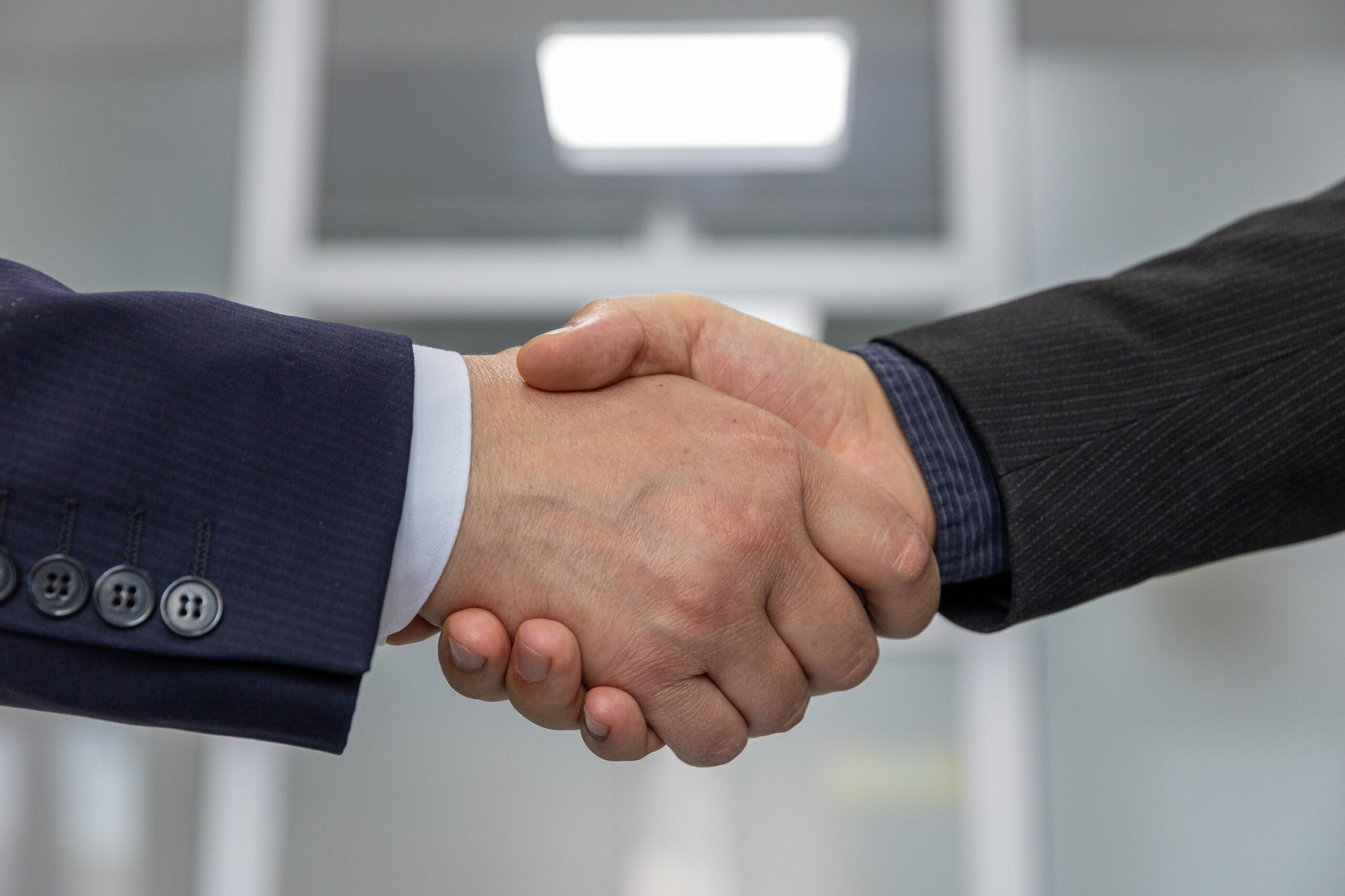 Two people shaking hands, representing a business partnership agreement like an affiliate commission deal