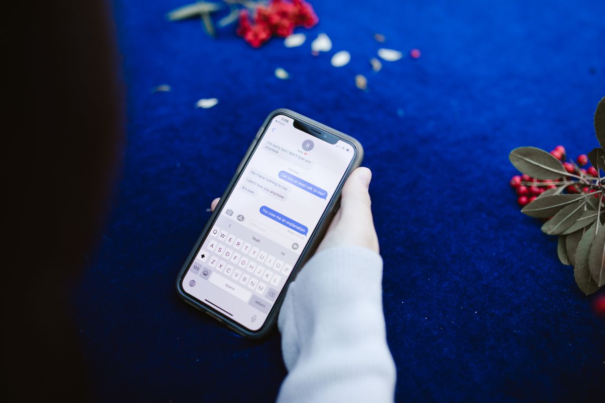 Hand holding a smartphone showing a private message conversation, representing fake customer support DM scams