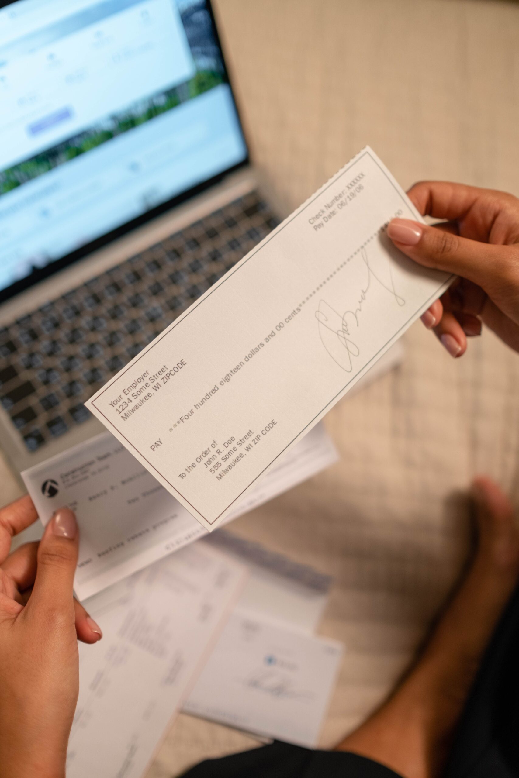 Illustrative photo of a hand holding a check, representing fake check and overpayment scams