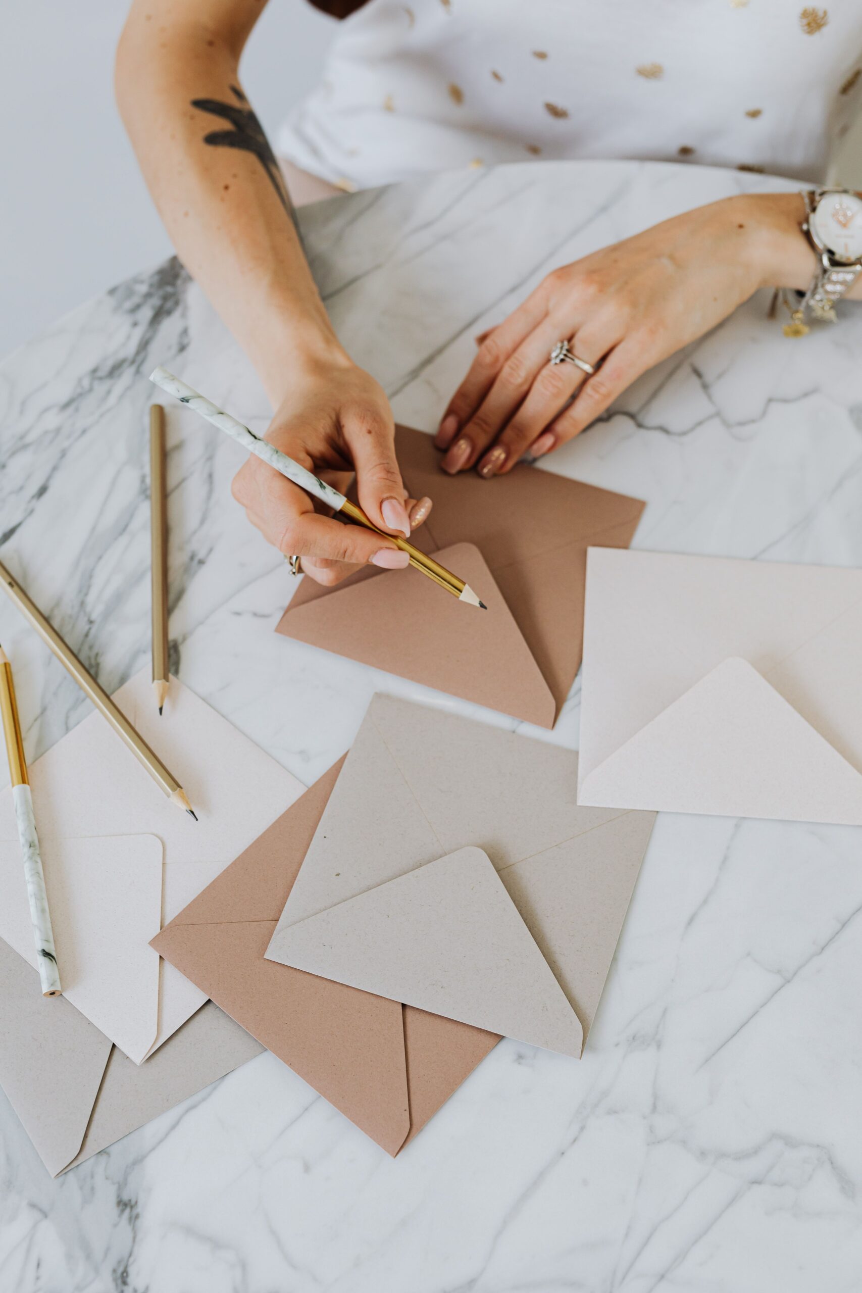 Illustrative photo of hands writing on envelopes, representing envelope stuffing and mailing job scams