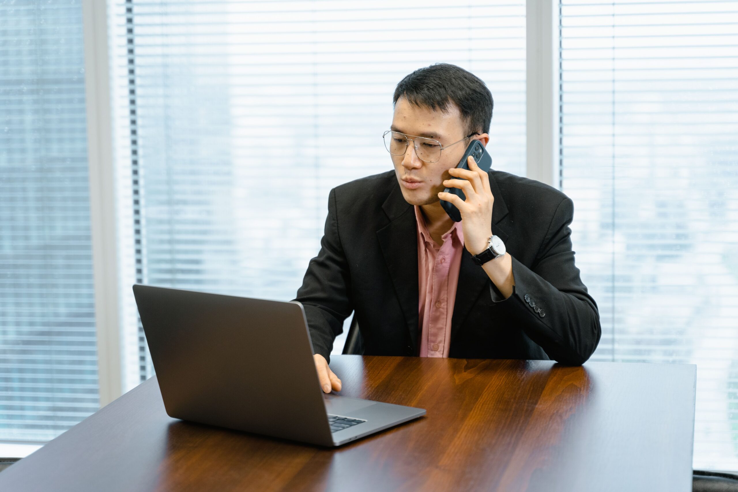 Illustrative photo of a person on a phone call at a laptop, representing a high-pressure mentorship application call