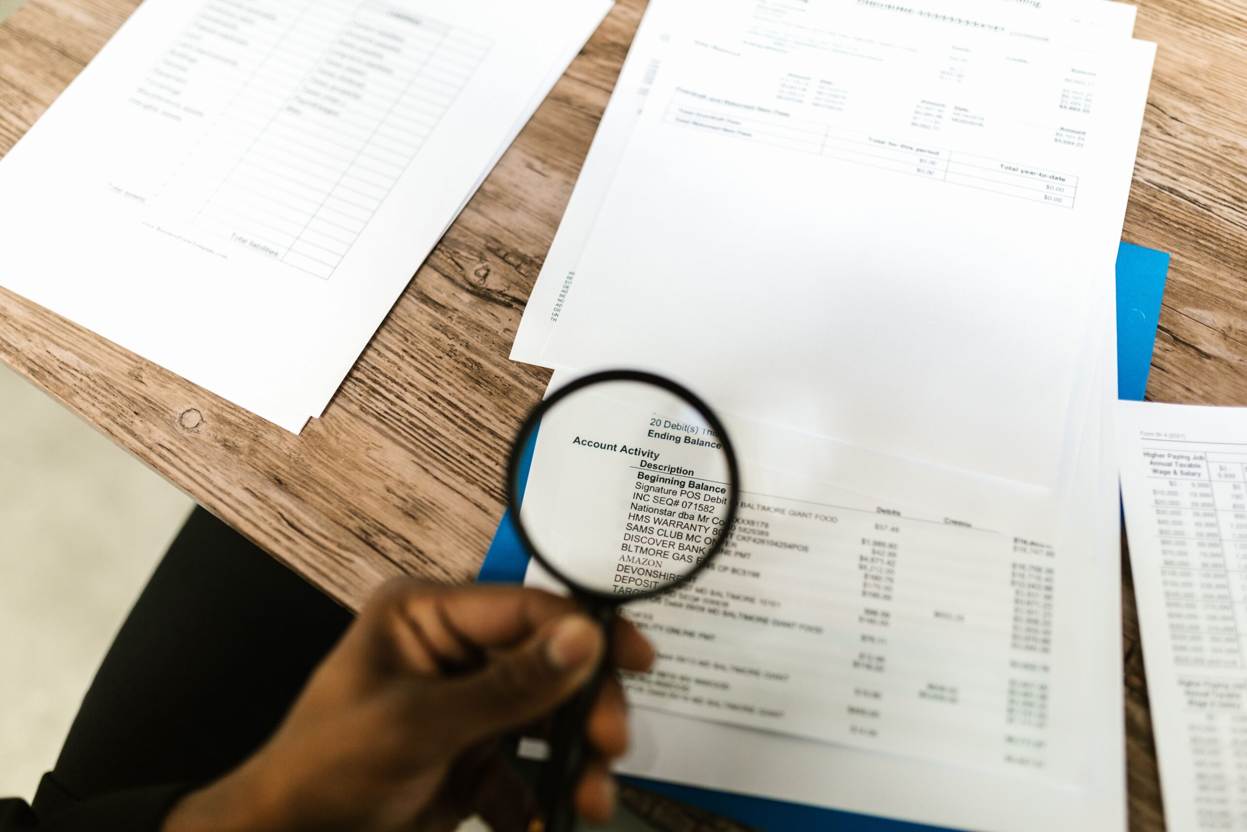 Illustrative photo of a magnifying glass over a document, representing hidden fine print in a refund policy