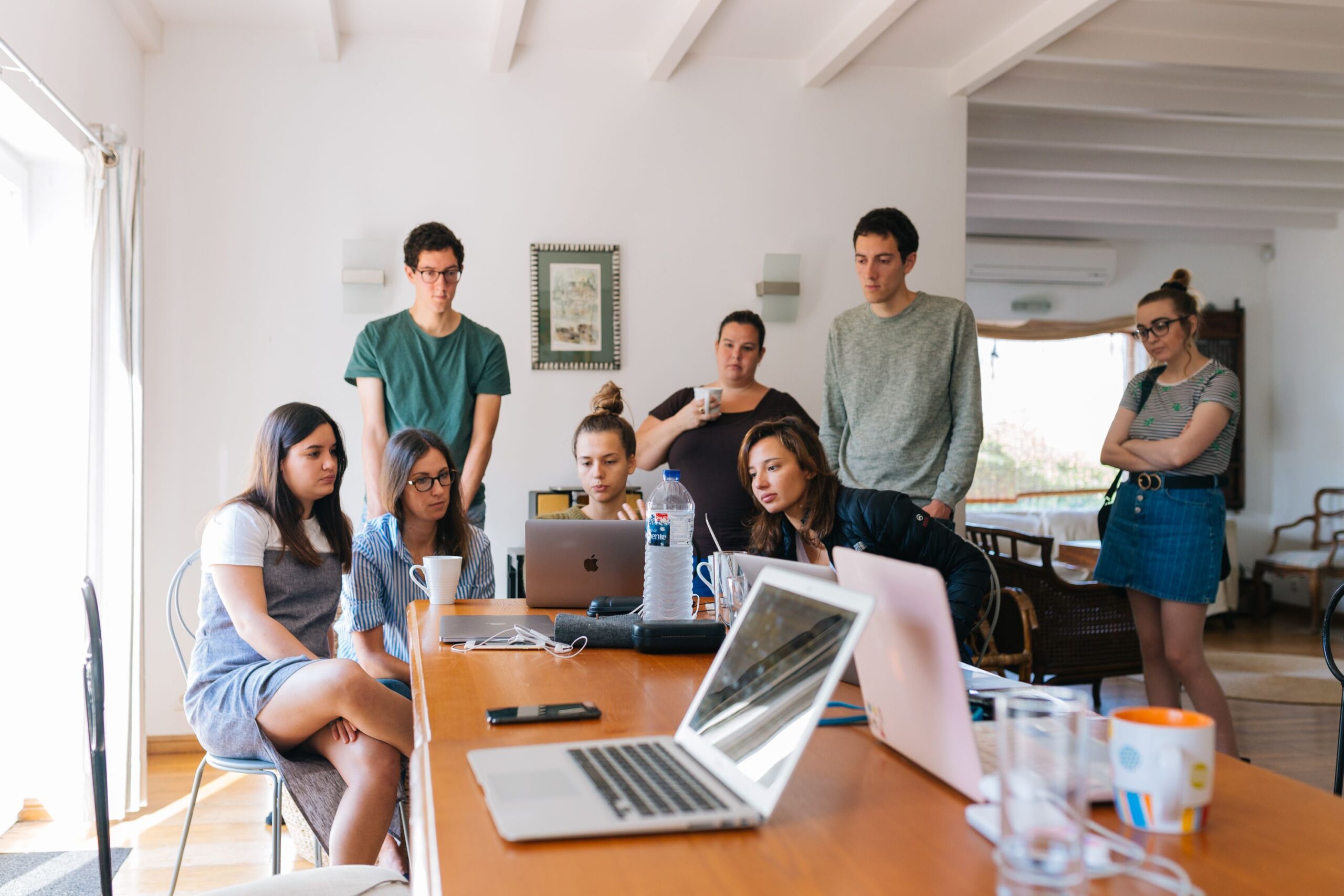 Illustrative photo of a group looking at a laptop together, representing a large group coaching program