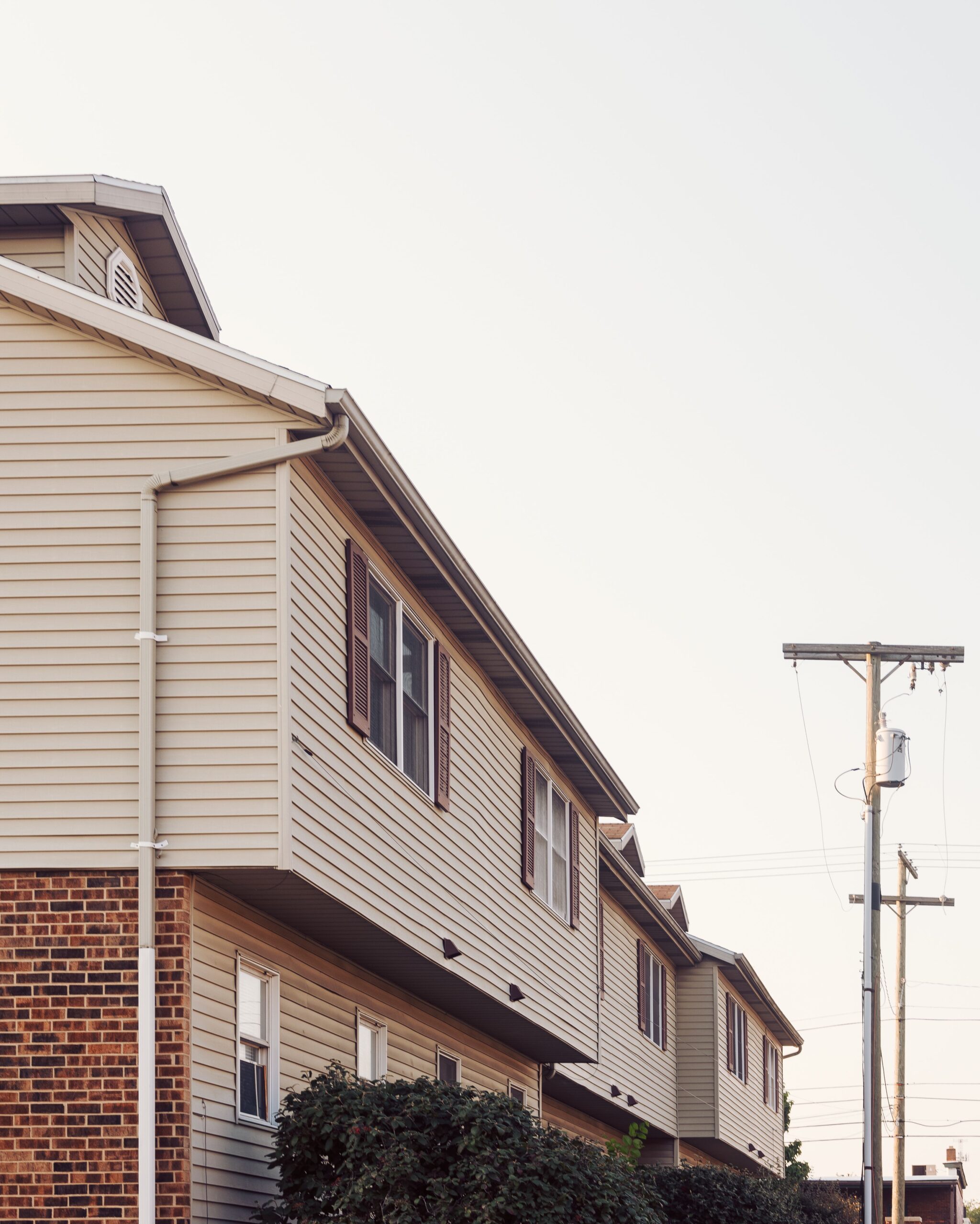 Exterior view of suburban row houses with siding and brick, representing a residential property